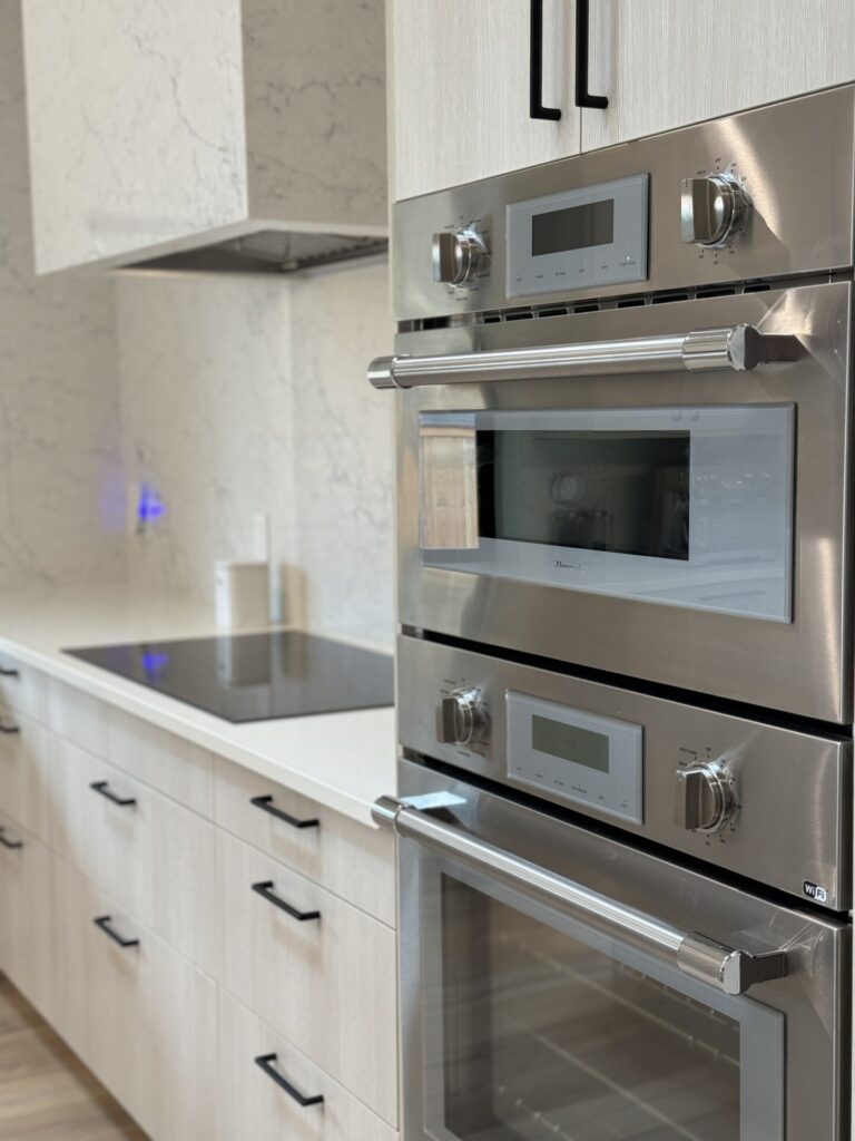 IKEA kitchen with existing stainless steel appliances and new SEKTION cabinets